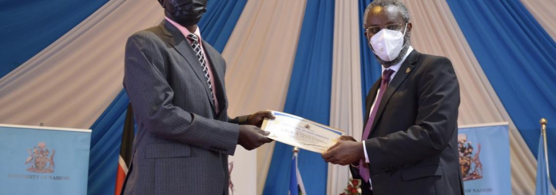 CASELAP Director, Dr Collins Odote receiving a certificate from UoN VC Prof. Stephen Kiama.